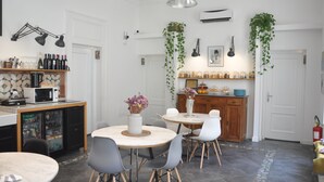 A modern kitchen with a dining area, featuring a refrigerator, microwave, and a variety of kitchenware. - Borgo Vergini Garden (Naples)