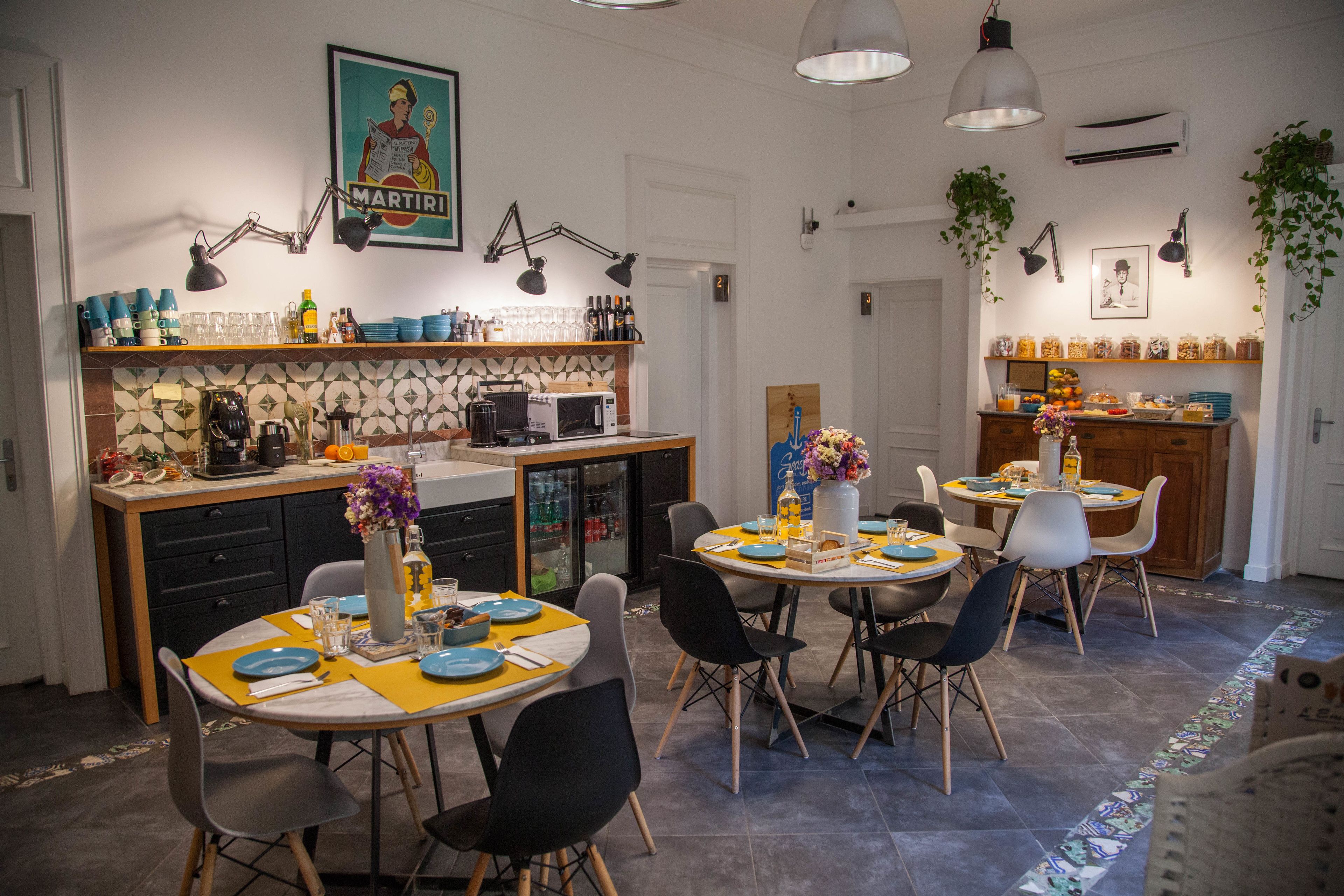 Uma cozinha moderna com área de refeições, destacando um revestimento de azulejos, armários de madeira e diversos eletrodomésticos.