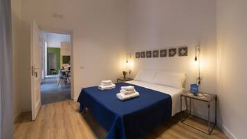 Une chambre d’hôtel comprenant un lit, des tables de chevet, un bureau et une chaise.