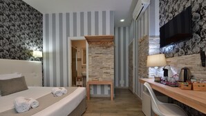 A hotel room with a bed, a desk, a chair, a TV, and a bathroom visible through an open door. - Rome Vatican Inn (Rome)