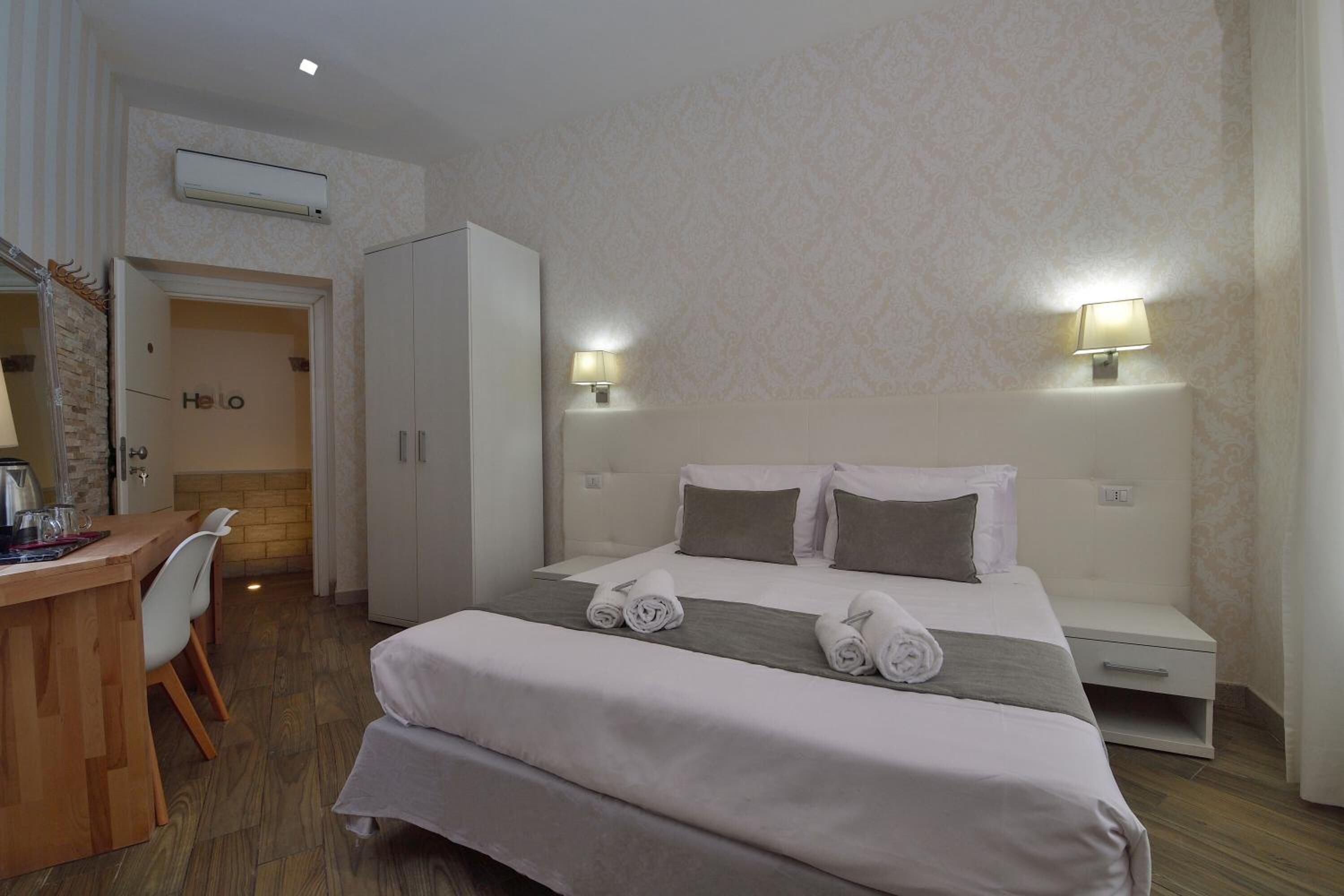 Une chambre d’hôtel avec un lit, un bureau et une armoire.