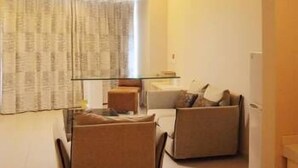 Un espace de vie compact comprenant un coin repas, un canapé et une petite table.