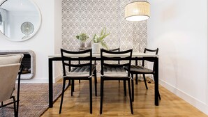 A dining area with a round mirror, patterned wallpaper, and a hanging lamp. - Genteel Home Retiro II (Madrid)