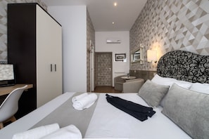 A hotel room with a bed, a desk, a chair, a wardrobe, and a bathroom. - Domus Pietro Inn (Rome)