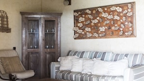 A room with a striped sofa, a wooden cabinet, and a wooden coffee table.