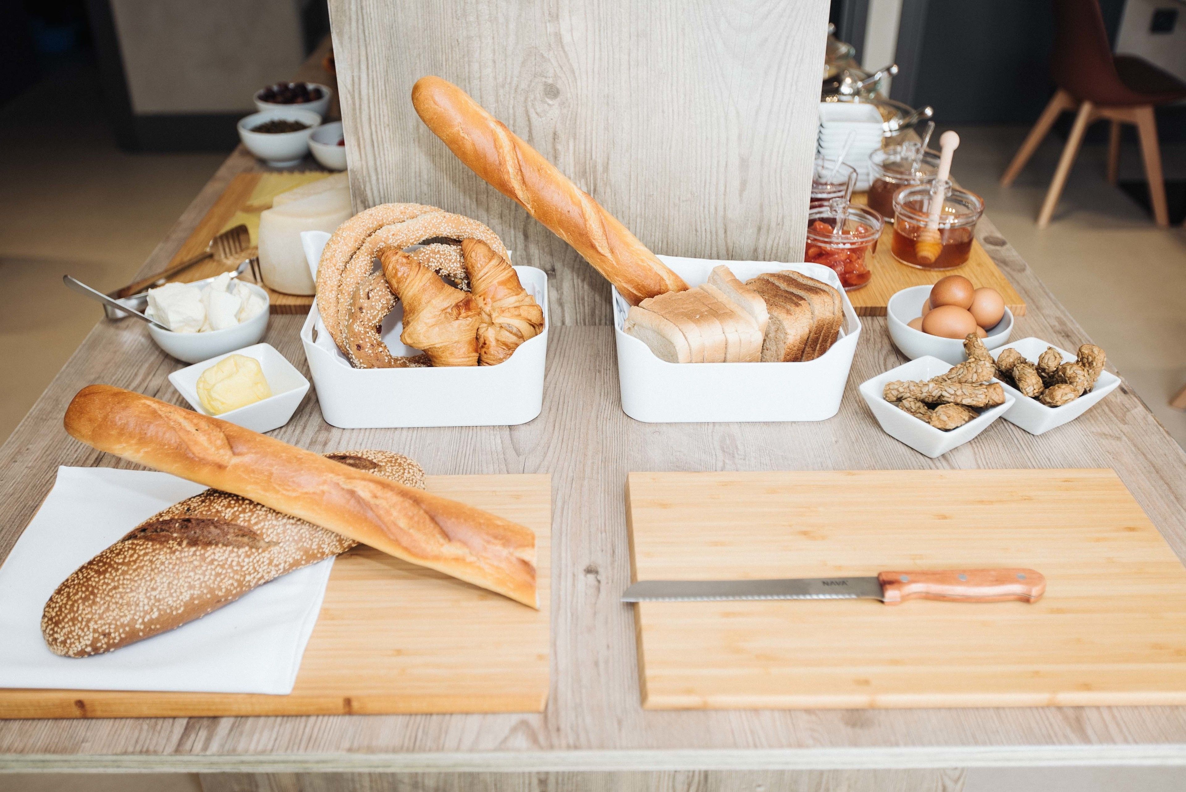 Una mesa de madera con diversos alimentos, como pan, queso y salsas.