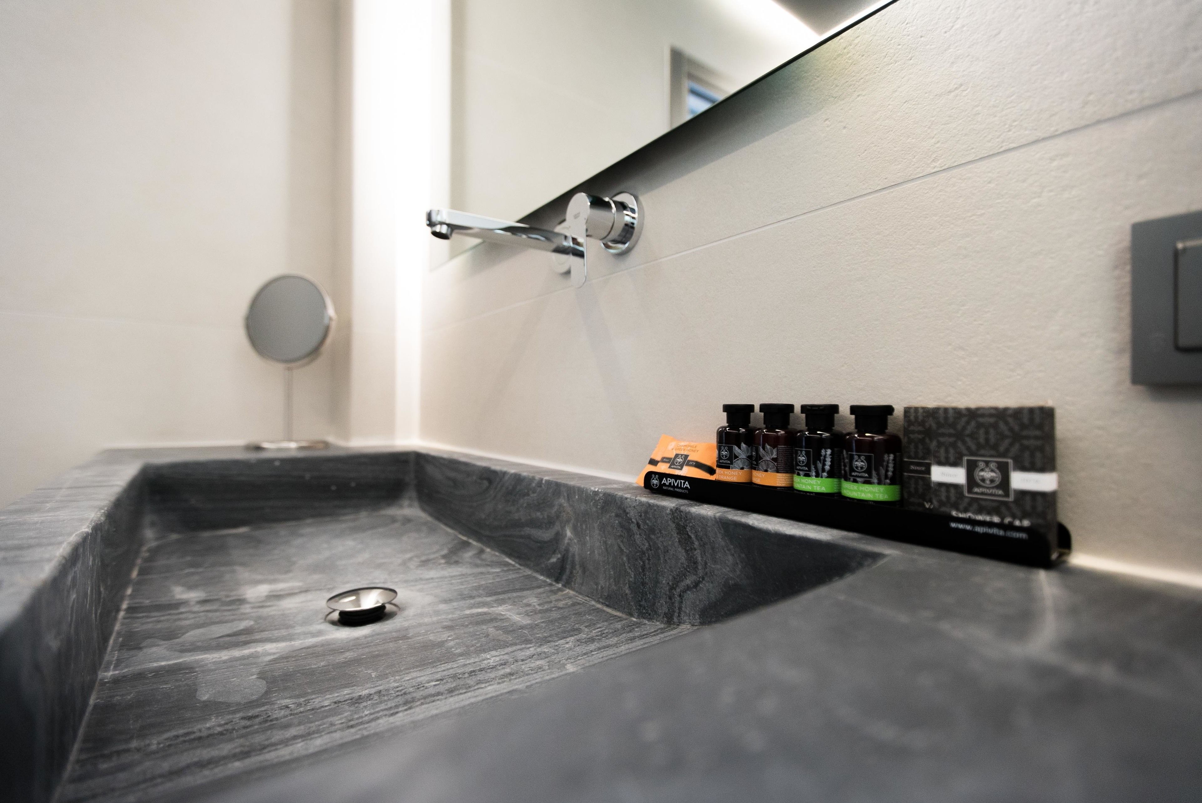 A bathroom sink with a marble basin, a faucet, and a soap dispenser.