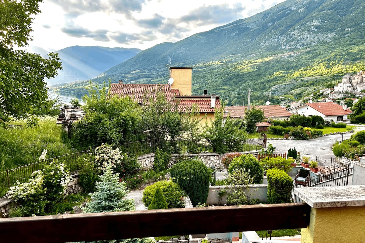 Un village de montagne aux bâtiments traditionnels, doté d’une route pavée et d’une végétation luxuriante.