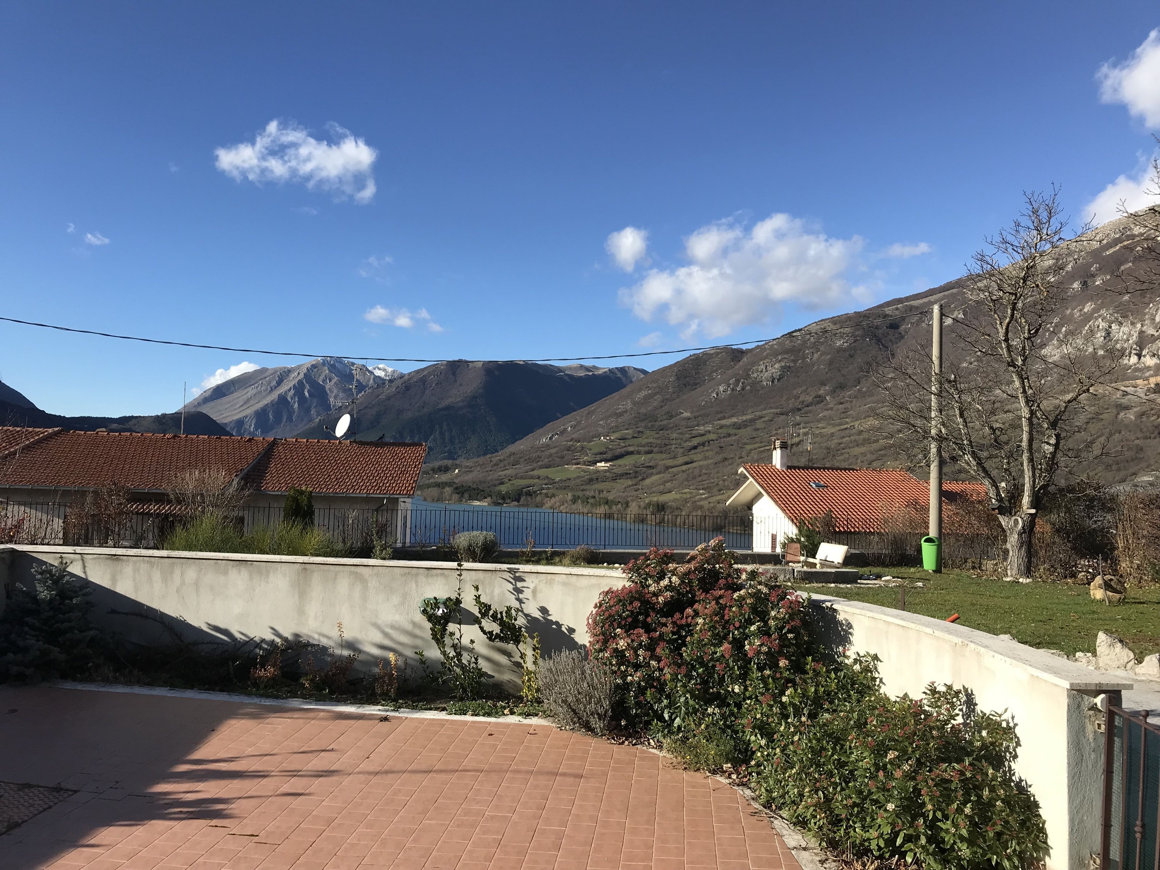 Zona residencial con casas, un sendero pavimentado y montañas al fondo.