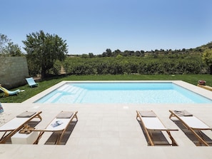 Piscine extérieure en saison, chaises longues