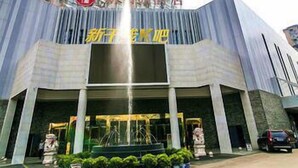 A hotel entrance with a fountain, a statue, and a row of potted plants. - Xinyiyuan Hotel (Changsha)