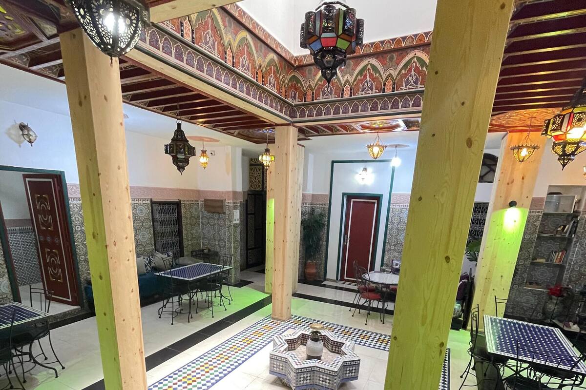A traditional interior with patterned flooring, wooden pillars, and hanging lanterns.
