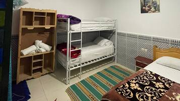 Un dormitorio con literas, un armario, una alfombra estampada y un techo con diseños elaborados.