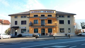 Un edificio a due piani con facciata gialla, un cartello che riporta 