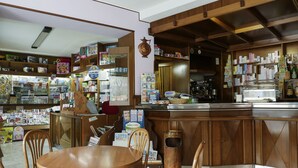 Una libreria con arredi in legno, scaffali pieni di libri e riviste, e un bancone con diversi articoli.