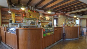 Un bar amb mostradors i prestatgeries de fusta plenes de garrafes.