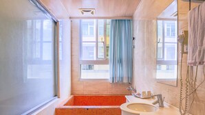 Un baño con bañera, lavamanos y ventana.
