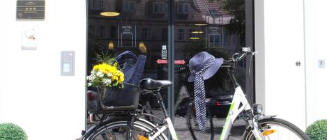 Entrada de hotel con una bicicleta estacionada adelante.