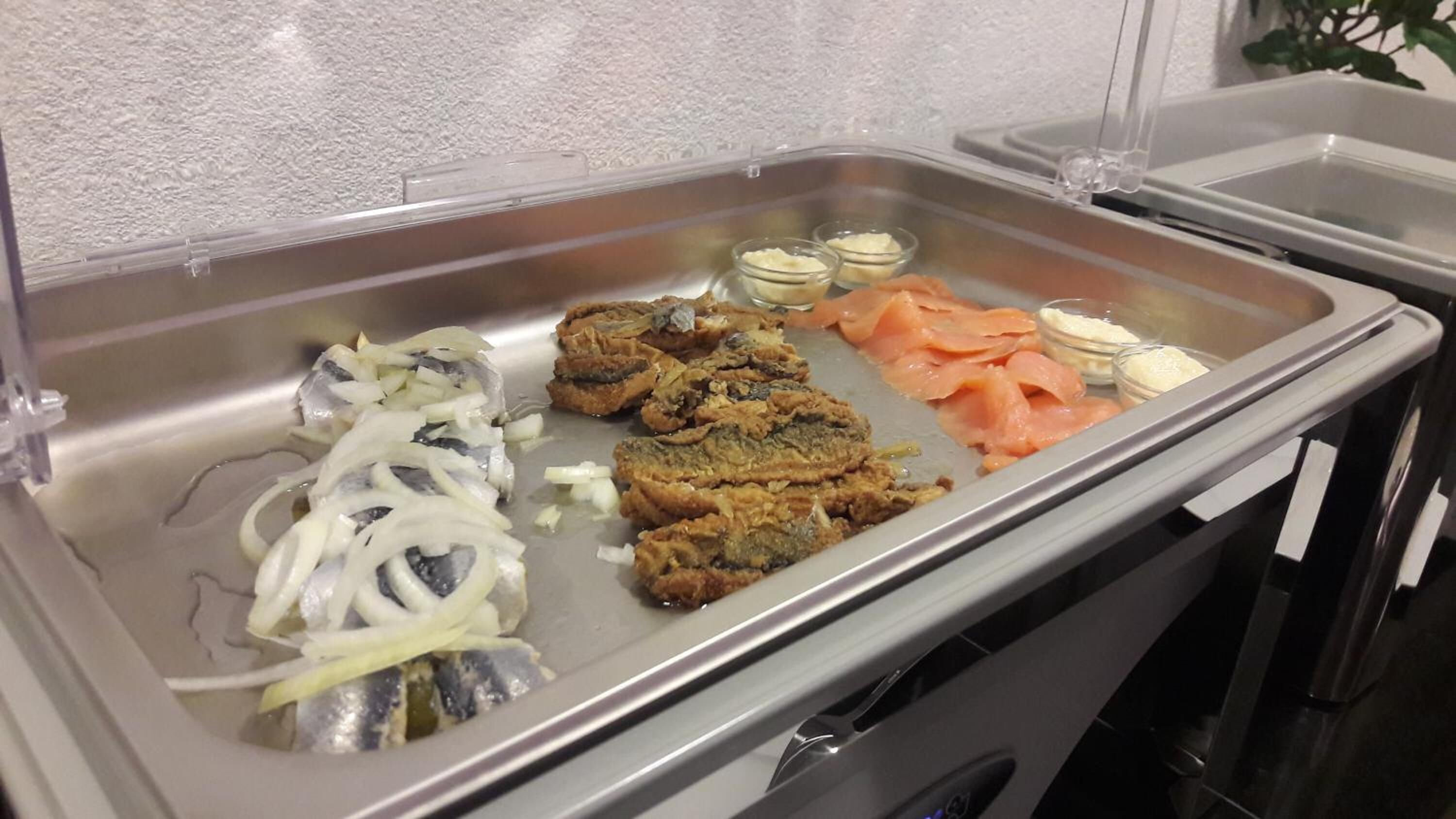 A buffet with various food items including fish, vegetables, and possibly some meat dishes.