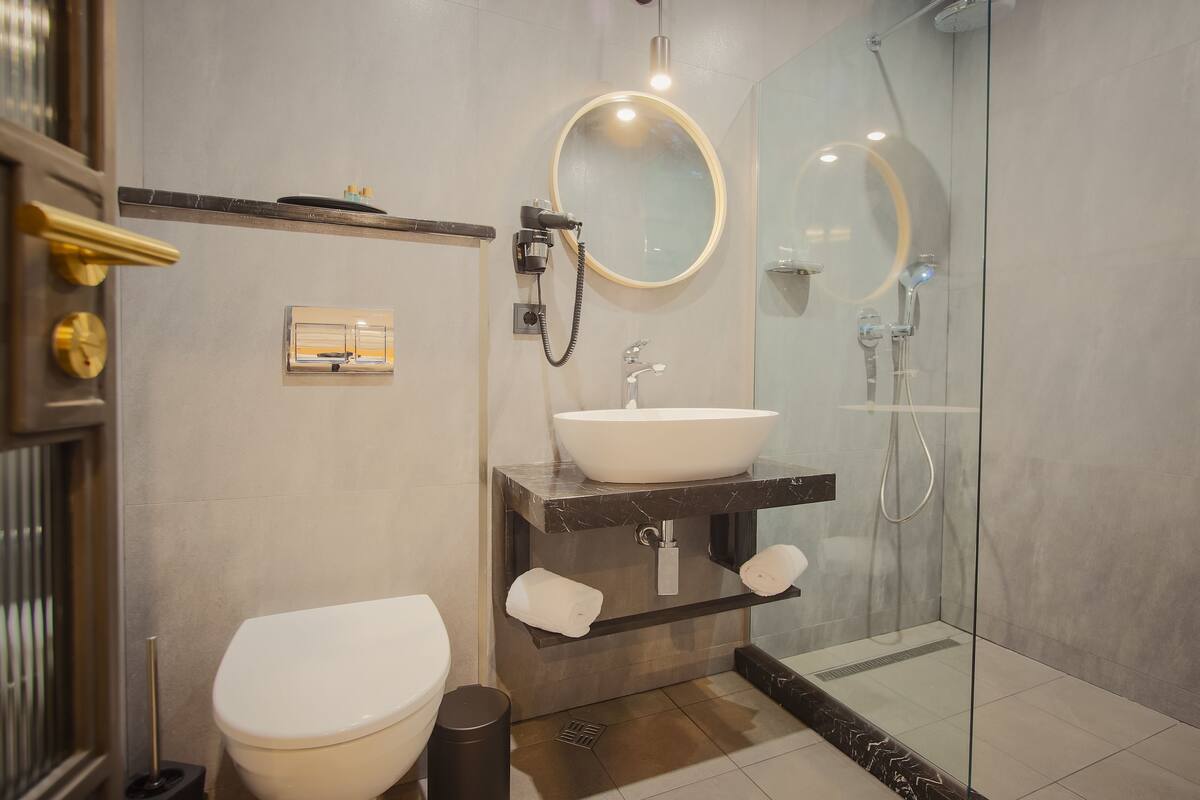 A modern bathroom with a toilet, sink, and shower.