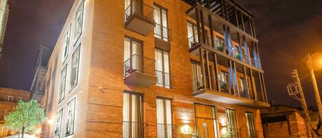 A multi-story building with balconies and a brick facade.