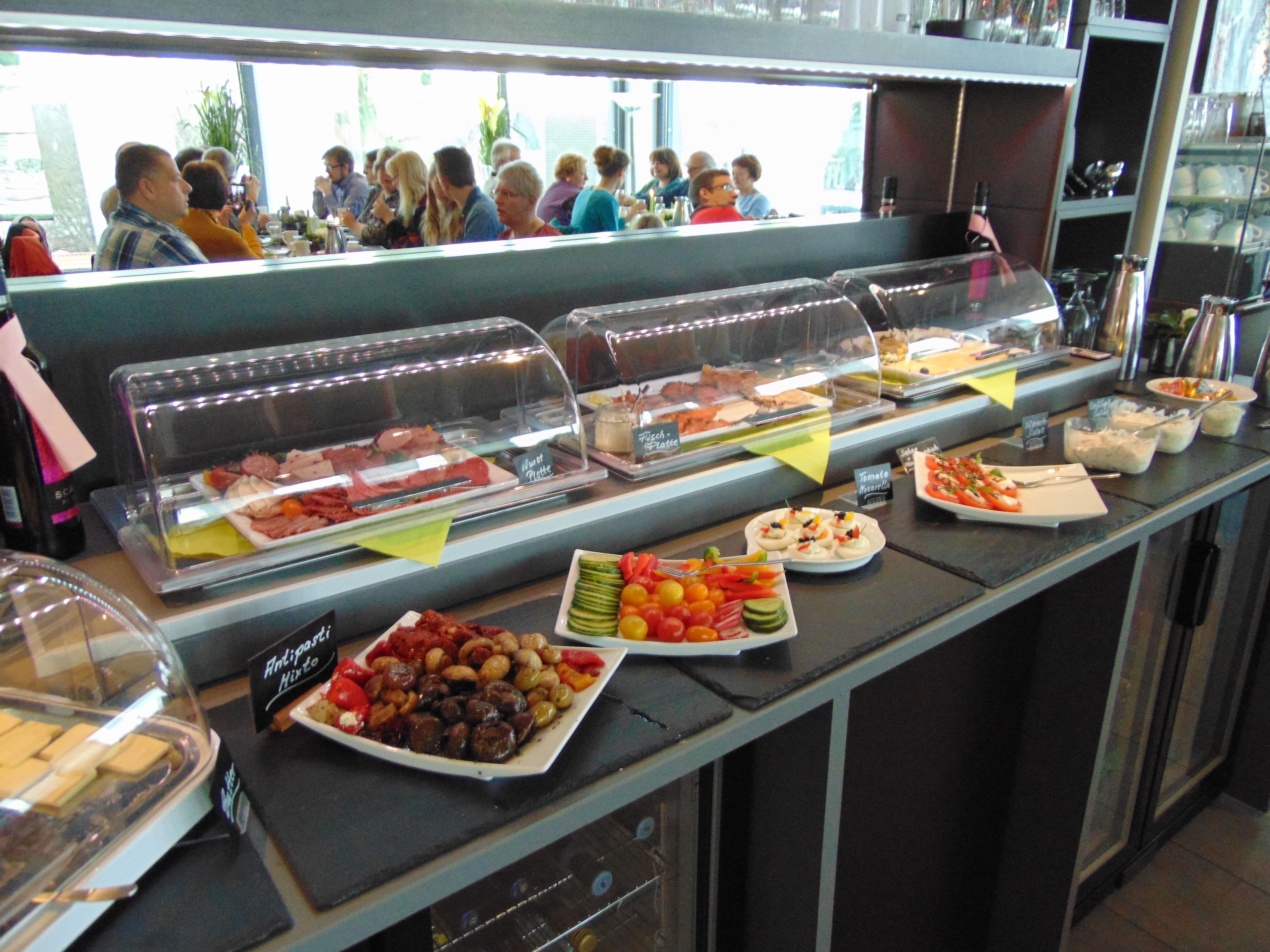 A buffet with various food options, including meats, cheeses, and vegetables.