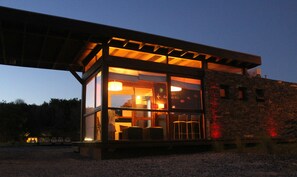 A modern building with large windows and a covered outdoor seating area. - Casas del Mar (Villa Gesell)