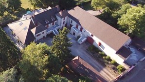 An aerial view of a large, multi-story building with a symmetrical facade, multiple windows, and a central courtyard. - La Conciergerie du Manoir (Saint-Léger-sur-Dheune)