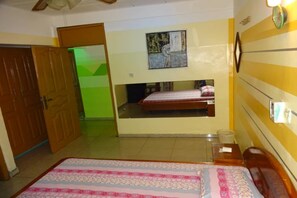 A room with a bed, a mirror, and a door. - Complexe Hôtelier Rond-Point (Abidjan)