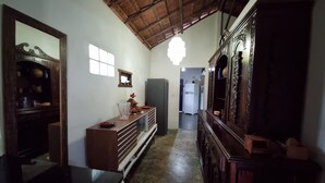 A narrow hallway with a wooden ceiling, a refrigerator, and a cabinet with decorative items. - House in Cumuruxatiba prox. Cliffs, mezzanine and spacious suite, sea view  (Prado)