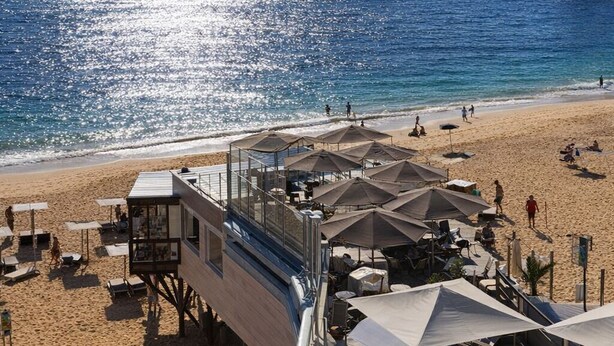 Un hôtel situé en bord de mer, doté d’une tour de surveillance pour les sauveteurs, de parasols et de chaises longues.