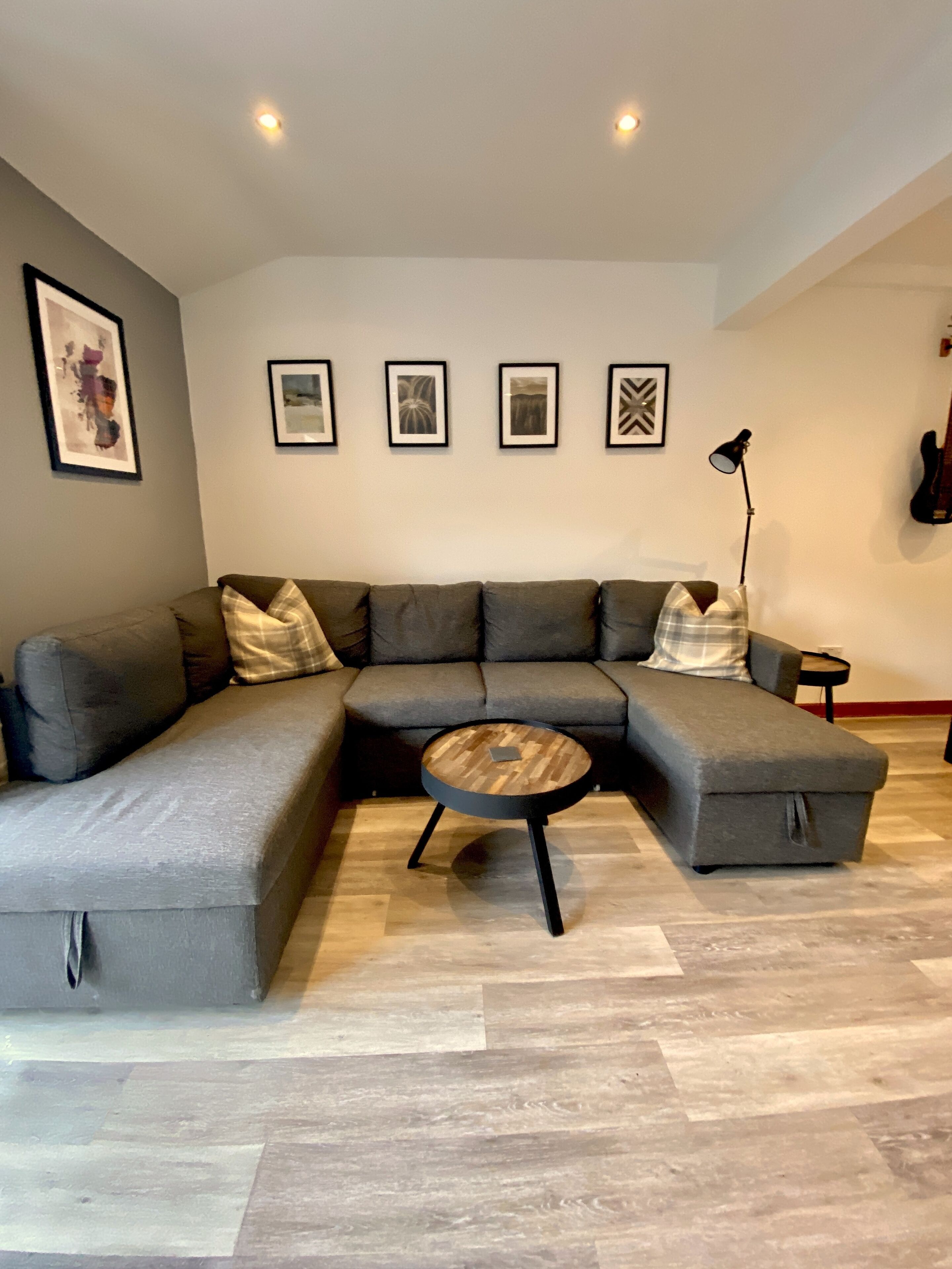 A modern living room with a sectional sofa, a round coffee table, and a floor lamp.