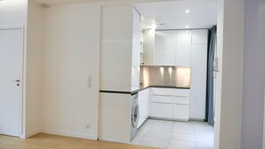 A modern kitchen with white cabinets, a washing machine, and a countertop. - CENTRAL = BEAUTIFUL Area ; MODERN BRIGHT Apartment (Paris)
