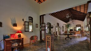 A spacious lobby with a high ceiling, wooden furniture, and a central table with a lamp. - Near Galle, recent colonial house, 3 bedrooms, large swimming pool in the park (Galle)