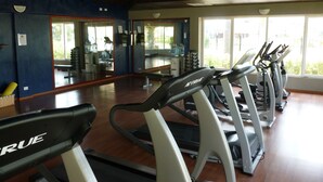 A gym with multiple treadmills, exercise equipment, and large windows allowing natural light. - Luxury, Eagle Beach Front 2BR, Penthouse  Private Roof Terrace (Eagle Beach)
