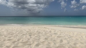A beach with clear turquoise water and a sandy shore. - Luxury, Eagle Beach Front 2BR, Penthouse  Private Roof Terrace (Eagle Beach)