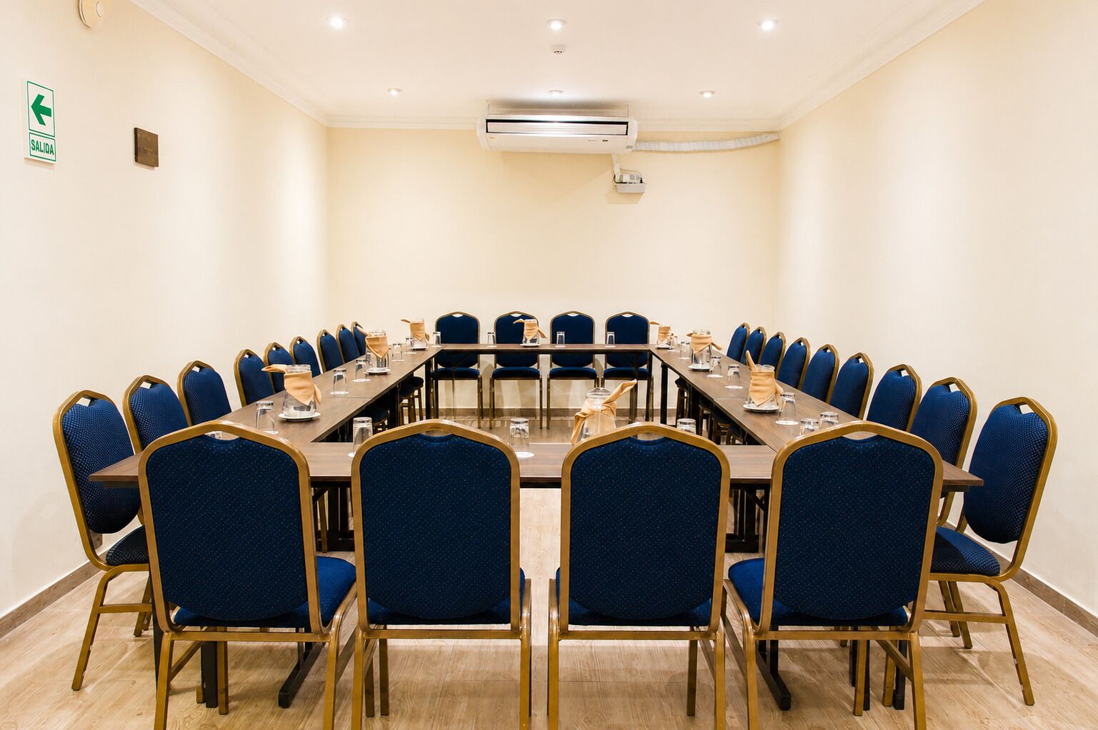 A conference room with a long table, blue chairs, and a whiteboard.