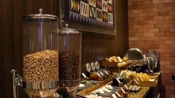 A buffet with various food items and a decorative wall.