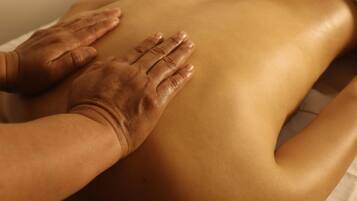 Een persoon ontvangt een rugmassage op een massagetafel.