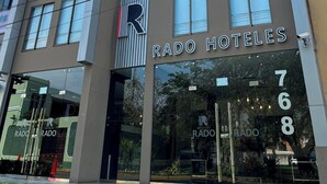 A modern hotel building with the name 'RADO HOTELES' prominently displayed on the facade. - Rado Hotel - Quintanas (Trujillo)