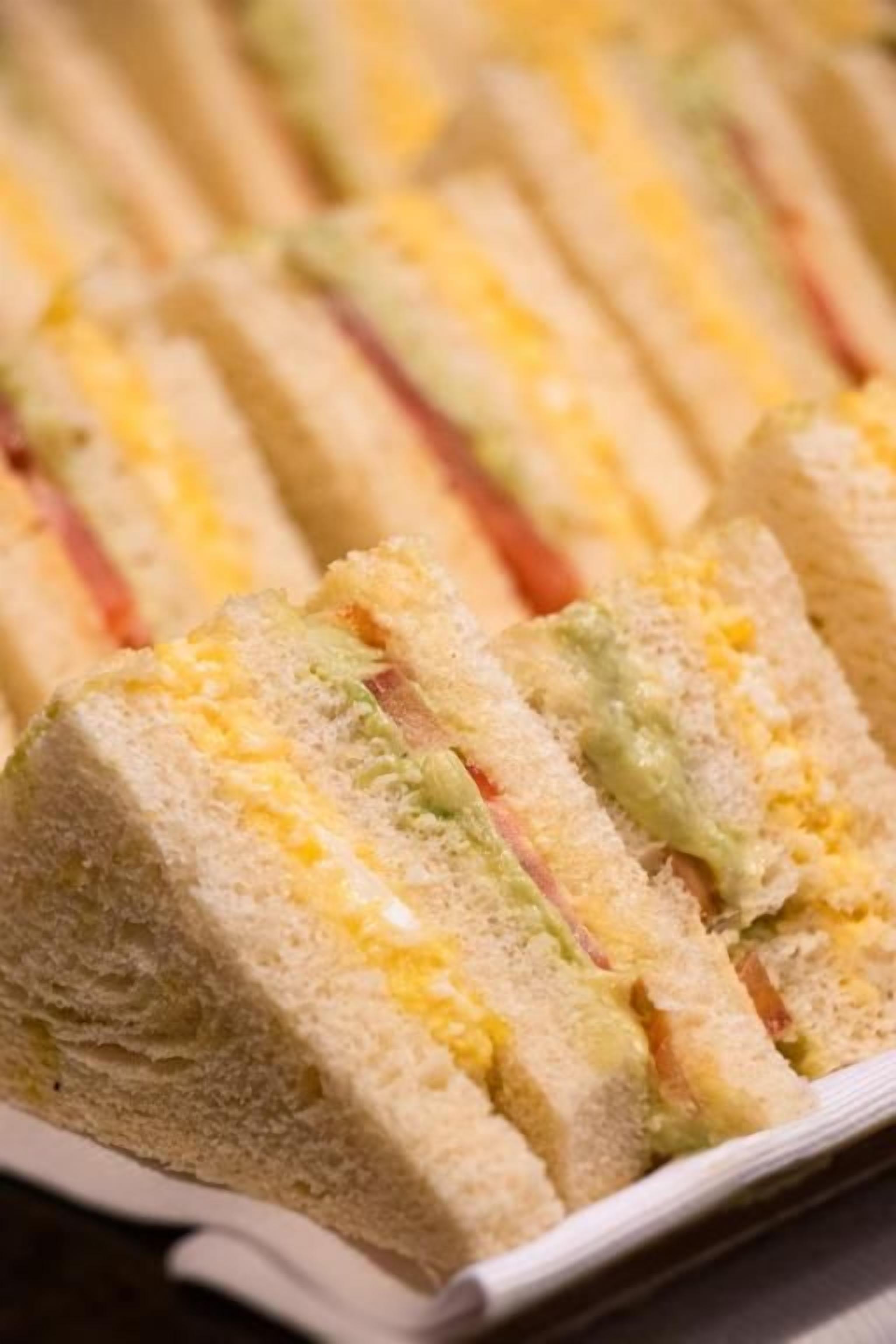 A tray of sandwiches with layers of ingredients.