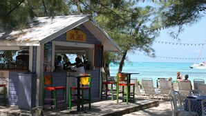 A beachside shack named "The Dak Shack" with outdoor seating and a view of the ocean. - Sea Paradise # 24 (Cayman Islands)