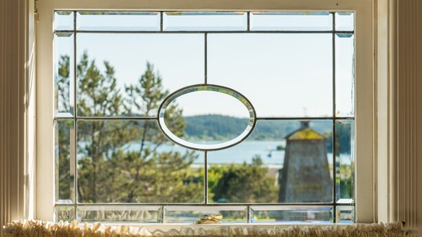 A window with a decorative glass pane and a circular mirror.