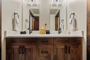 A bathroom with a double sink, wooden vanity, and a mirror above the sink. - Perfect location, walk to Main St! RENOVATIONS complete for 2025/2026! (Park City)