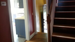 Un escalier menant à un palier avec une porte donnant sur une cuisine.