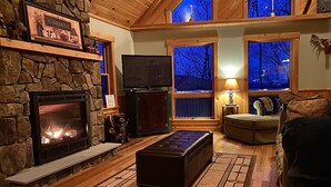 A cozy living room with a stone fireplace, a television, and a comfortable seating area. - True North at Sunday River-Powder Ridge-4miles to Mtn. New Air Conditioning !! (Newry)