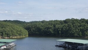 Un lago con barche ormeggiate e una riva costeggiata da alberi.
