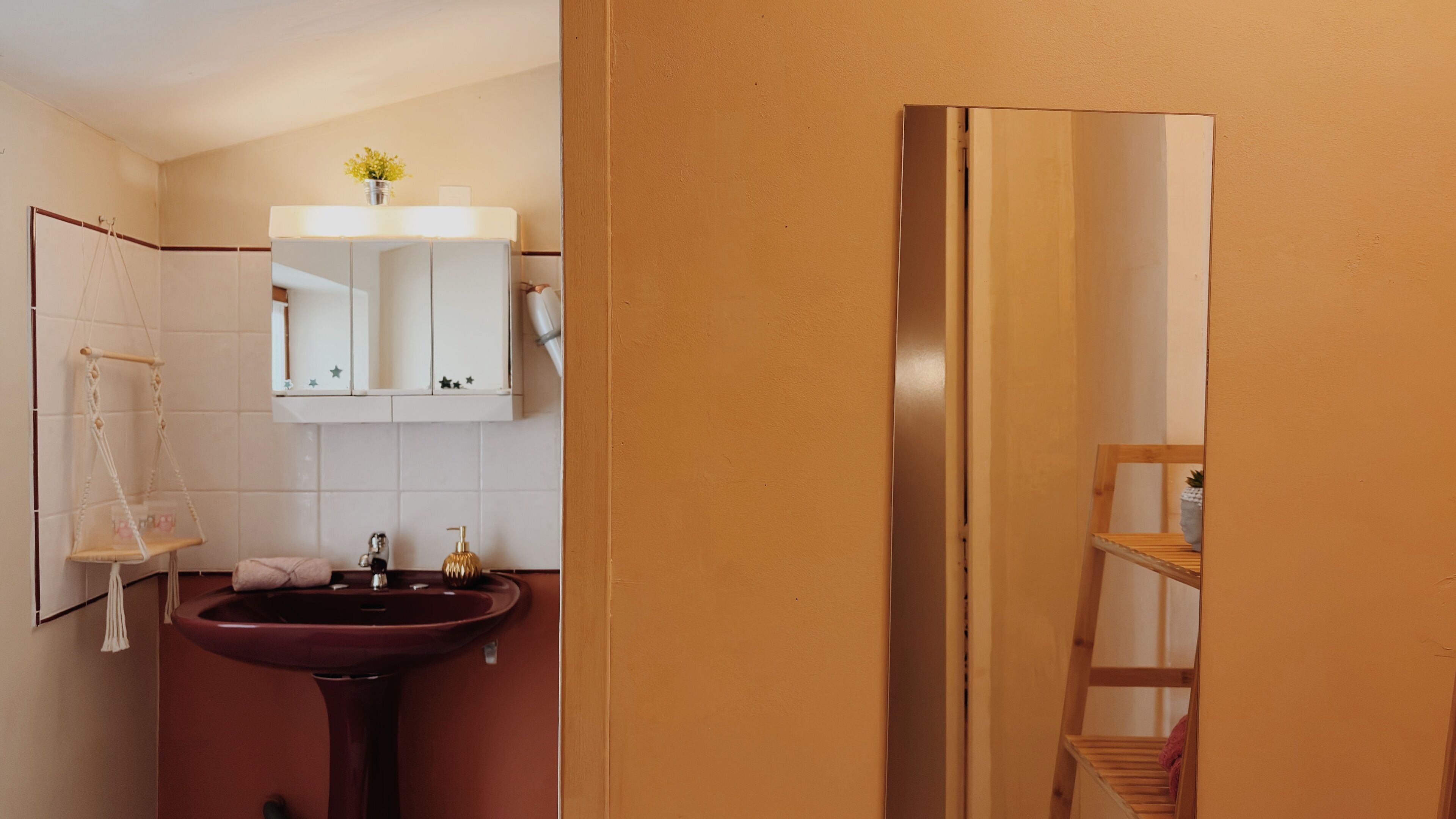 A bathroom with a vanity, a sink, a mirror, and a hanging macrame chair.