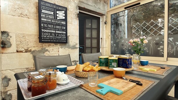 Un plateau de petit-déjeuner comprenant une assiette de pain, des pots de confiture, une théière et une tasse de thé.