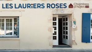 Un hôtel appelé « LES LAURIERS ROSES » avec une enseigne indiquant qu’il propose également un service de chambre d’hôtes.